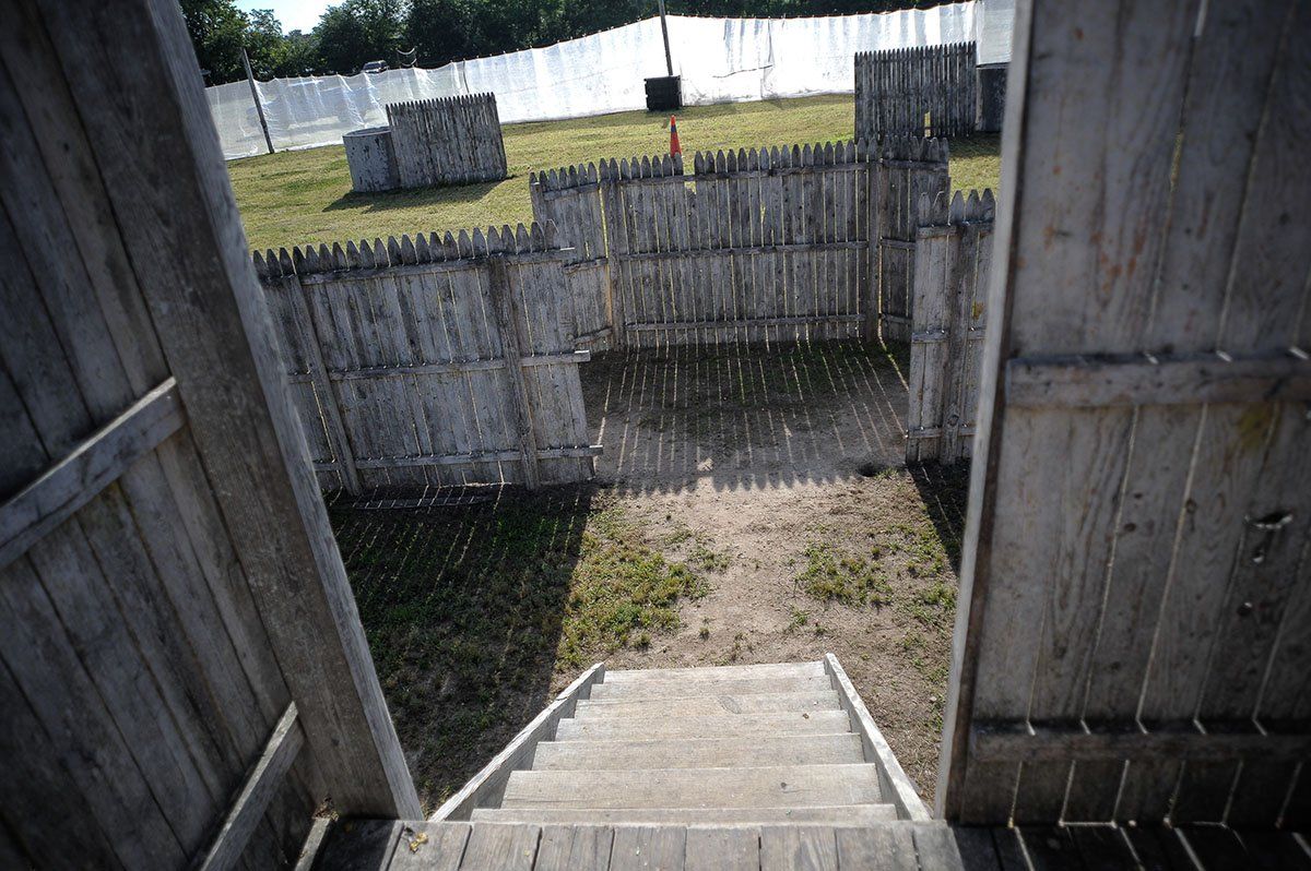 A set of stairs leading up to a fenced in area.