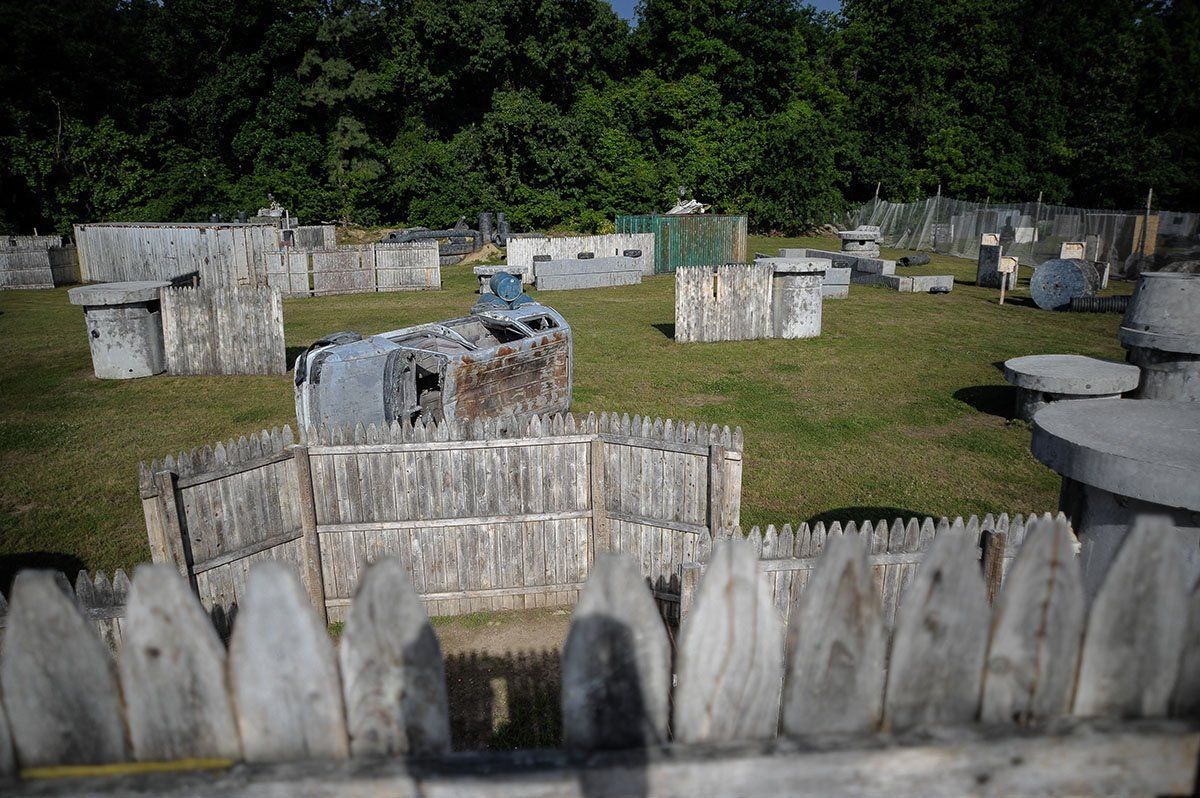 A paintball field with a wooden fence in the foreground.