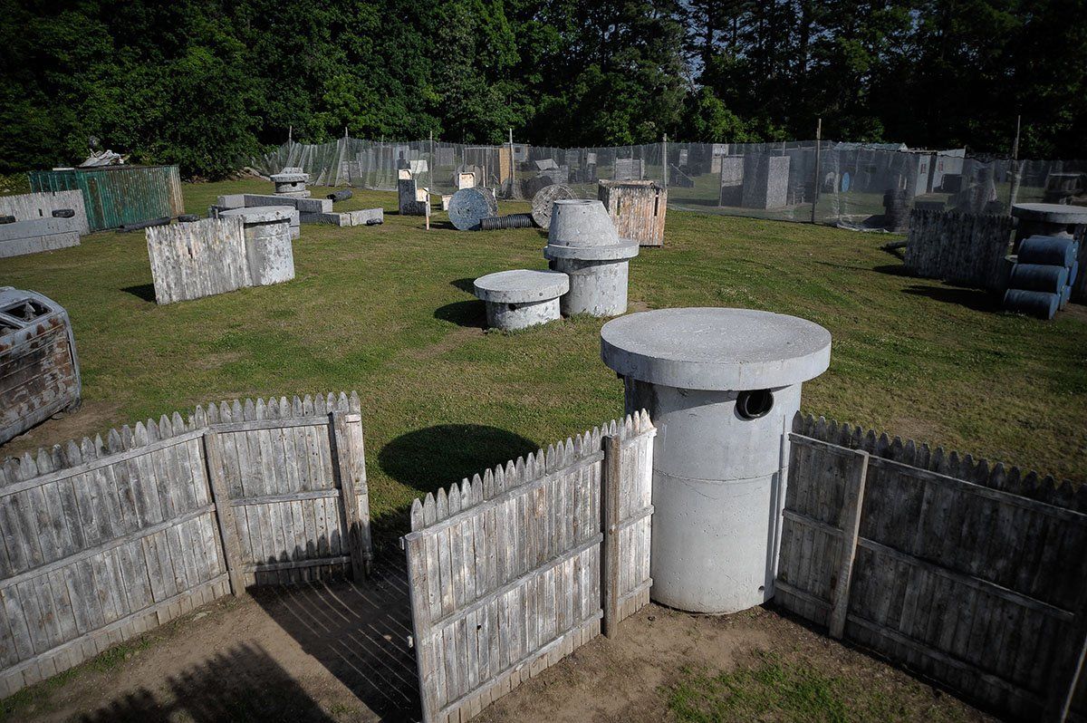 A paintball field with a fence and a table in the middle of it.