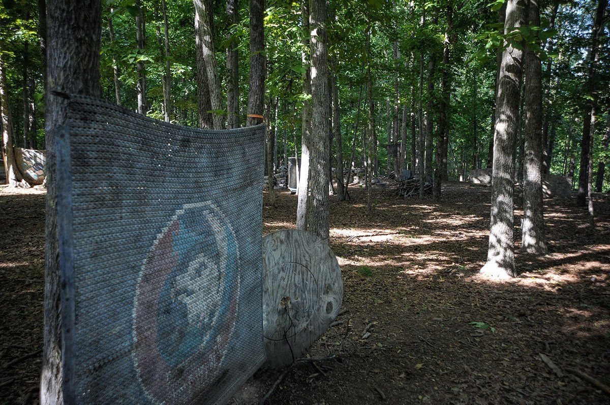 A large rock in the middle of a forest with trees in the background.