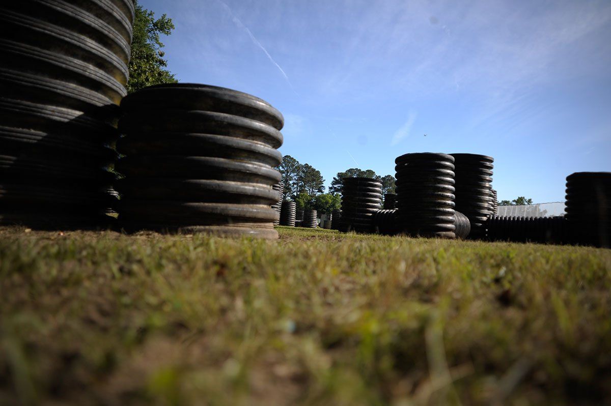 A bunch of tires are stacked on top of each other in a field.