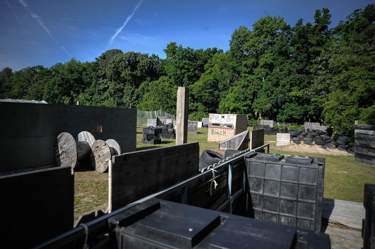 A paintball field with a lot of boxes and trees in the background