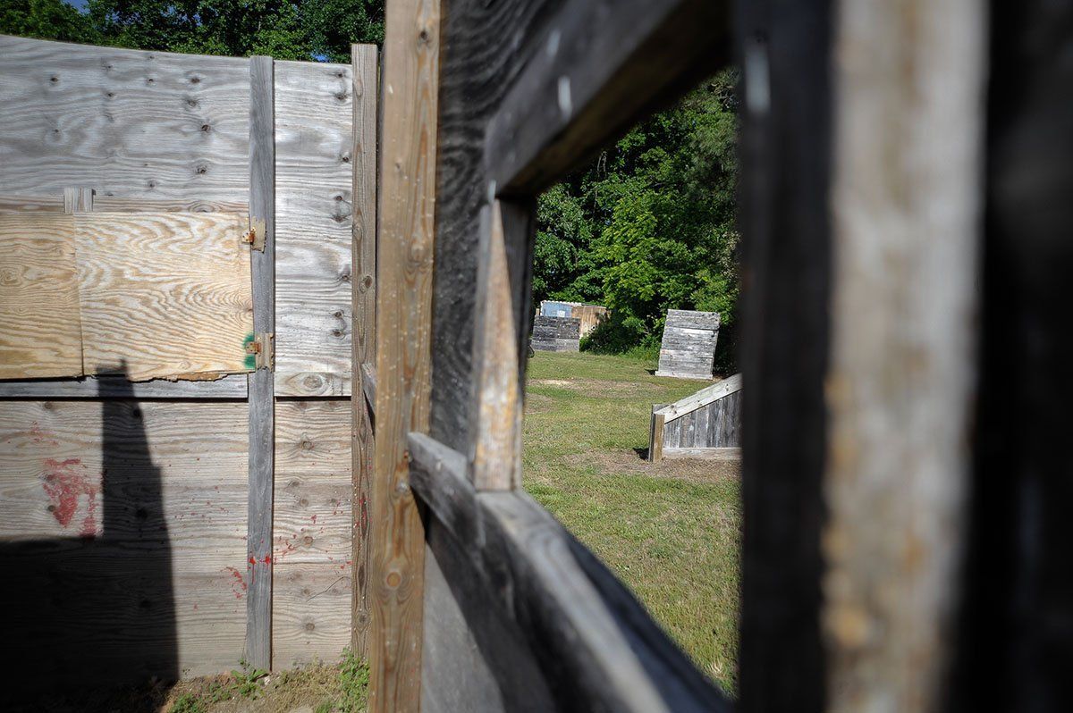 A wooden fence with a window in the middle of it.