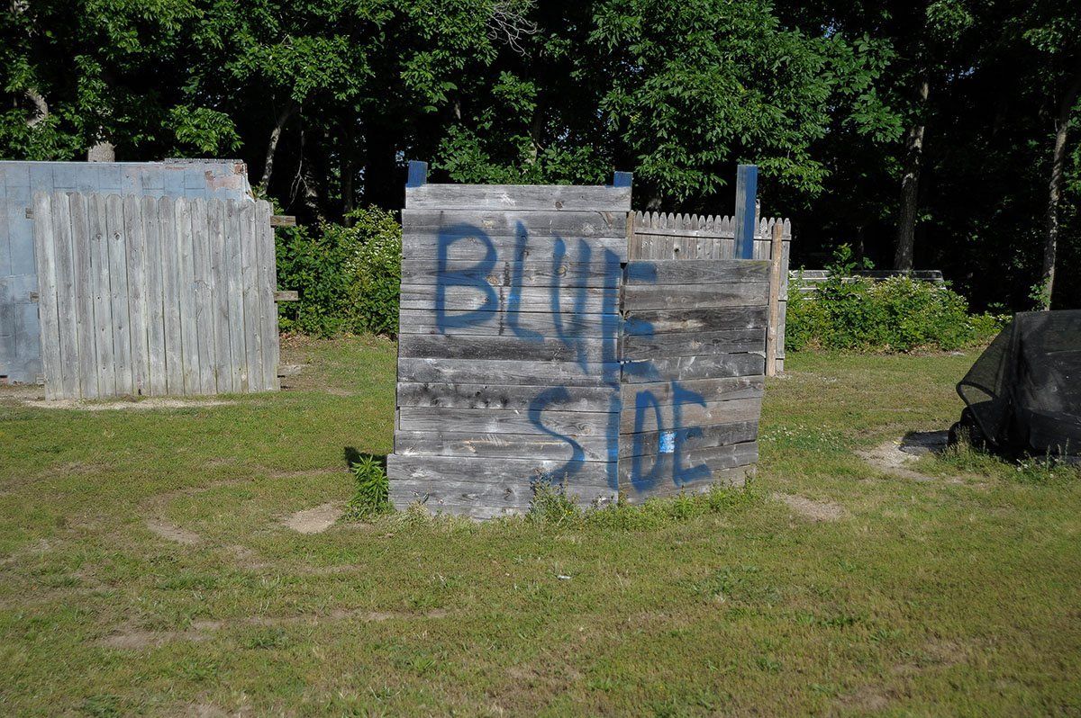 A wooden sign in a field that says blue side