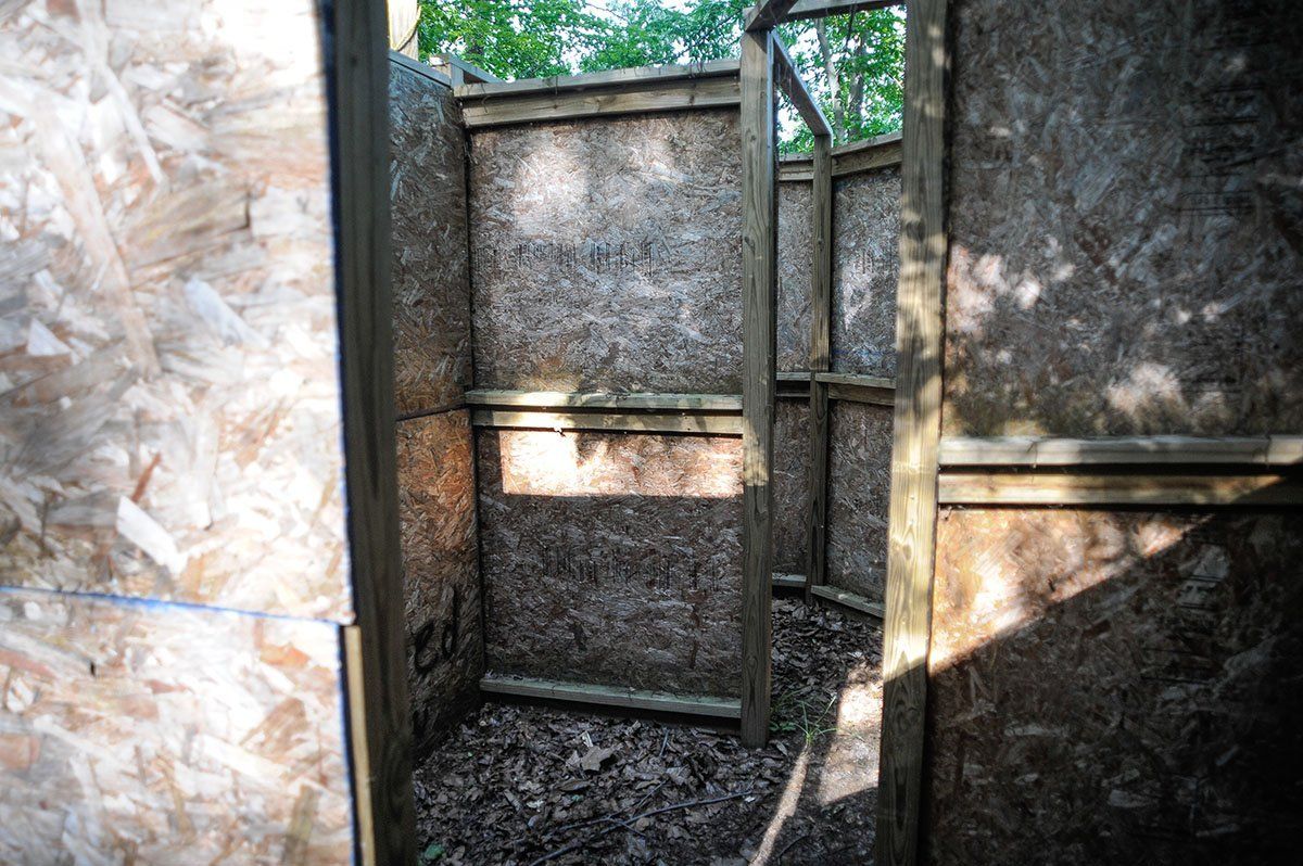 Meat Grinder Field - Inside The inside of a wooden building with a door and a window.