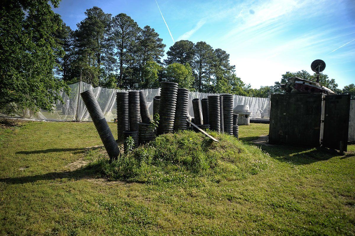 A bunch of tires are sitting on top of a grassy hill in a field.