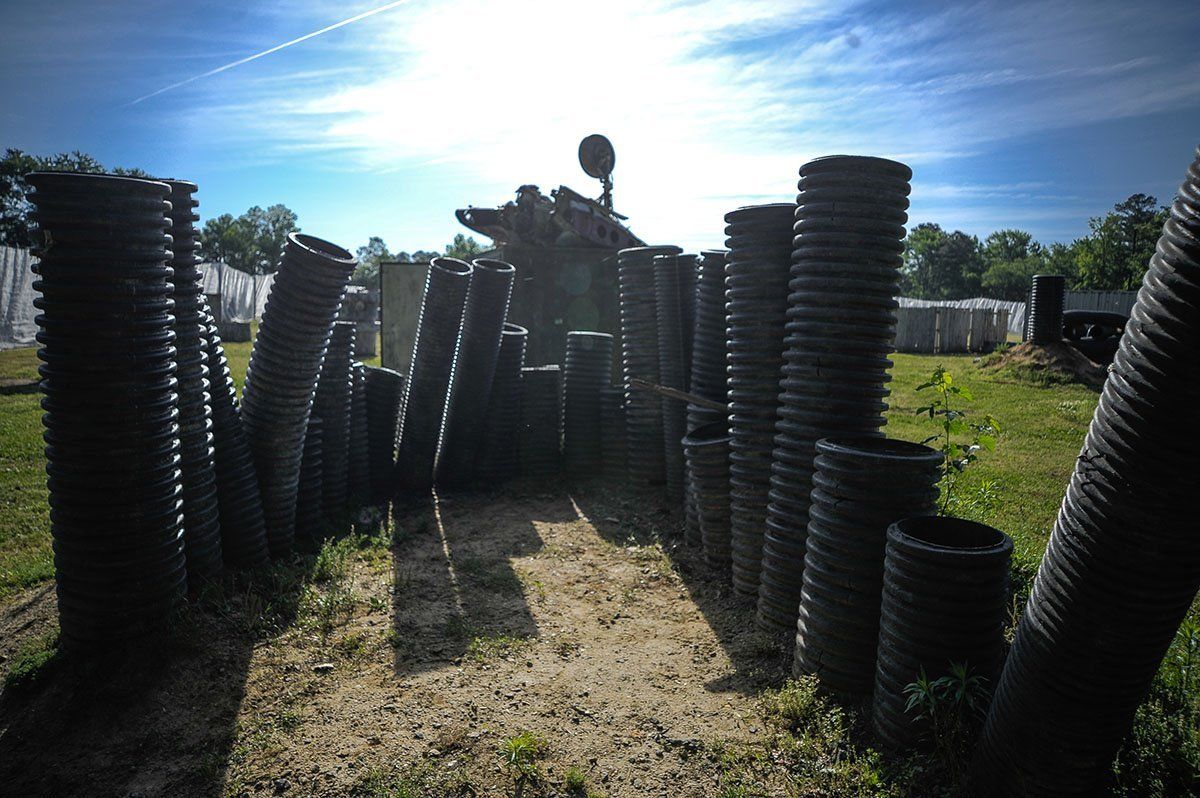 A bunch of pipes are stacked on top of each other in a field.