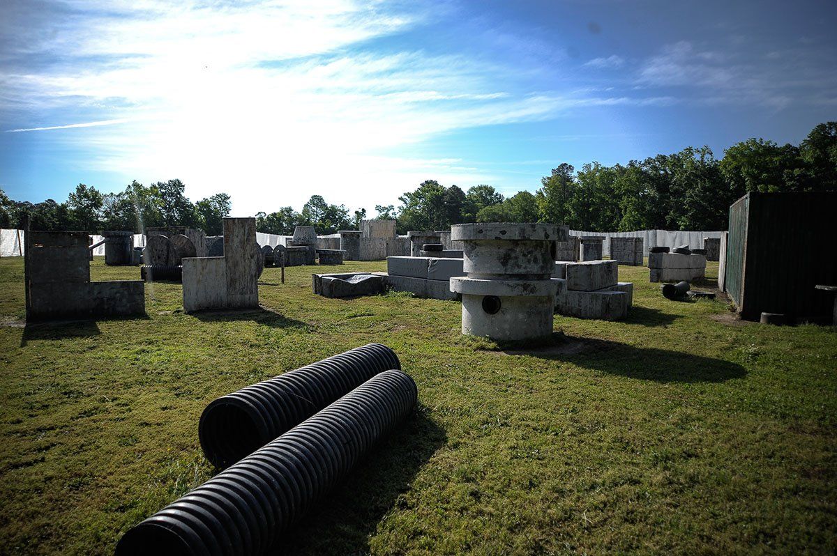 A paintball field with a blue sky and trees in the background