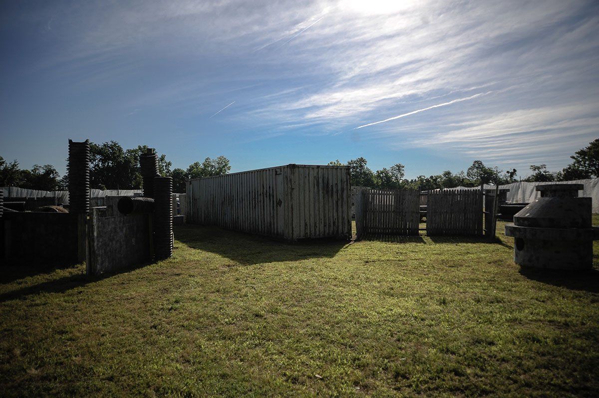 A paintball field with a lot of bunkers and trees in the background.
