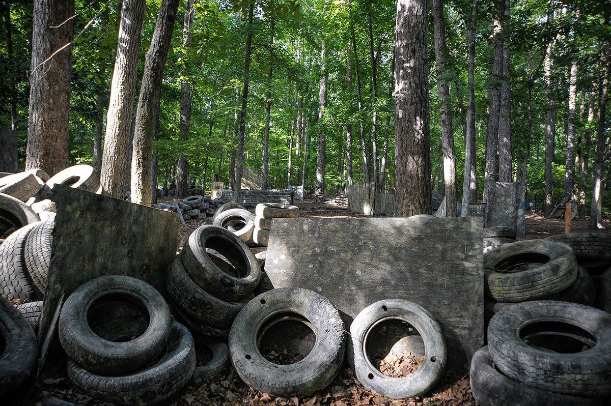 A pile of tires in the middle of a forest.