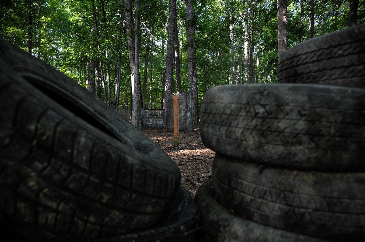 A pile of tires in the middle of a forest.