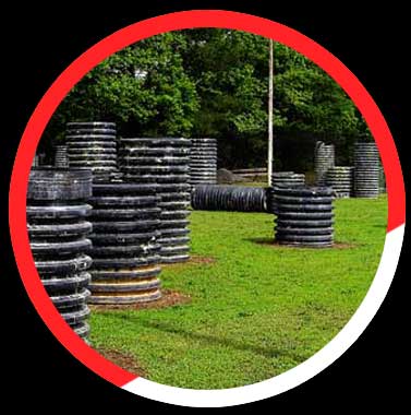 Click here to see more details. A bunch of tires are stacked on top of each other in a field