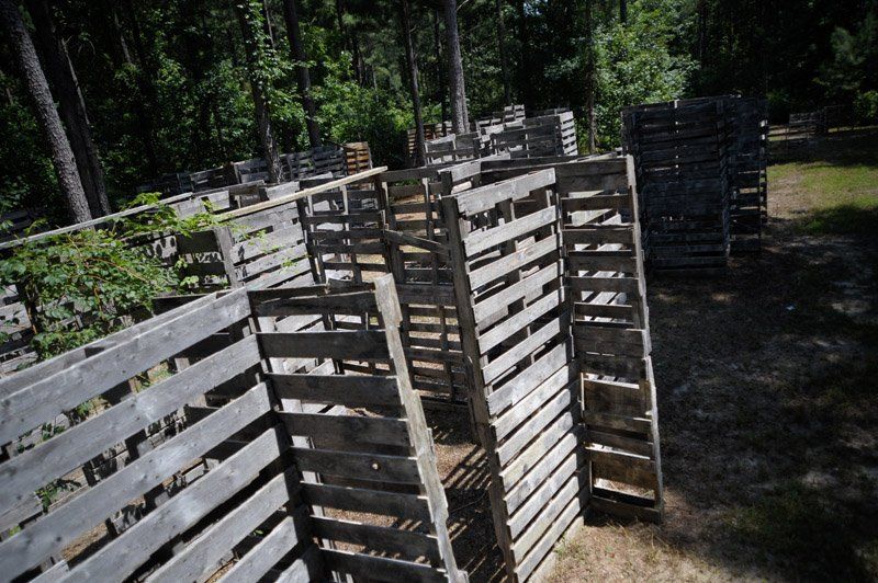A maze made out of wooden pallets in the middle of a forest.