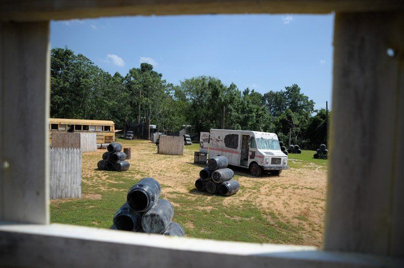 Nuke Town Field A white van is parked in the middle of a paintball field.