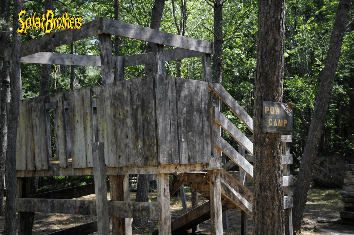 A wooden tree house in the woods with a sign that says for camp