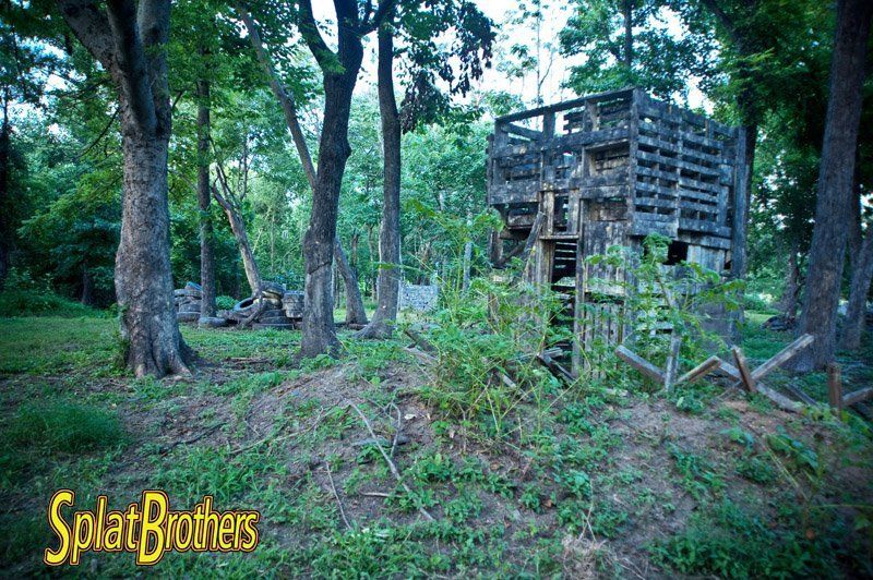 A wooden structure in the middle of a forest with the words splatbrothers written on the bottom