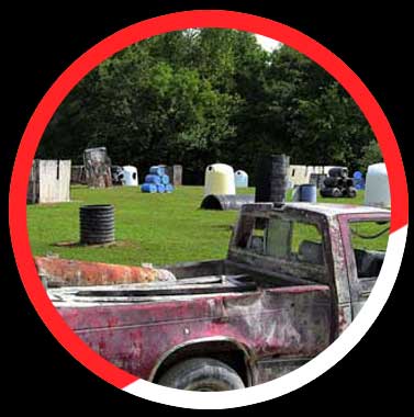 Click here to see more details. A paintball field with a truck in the middle