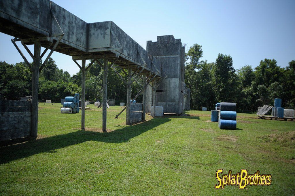 A paintball field with a large building in the background