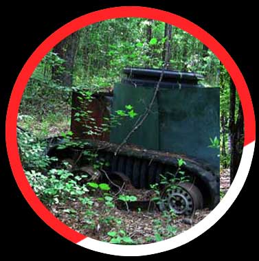 Click here to see more details. An old military vehicle is sitting in the middle of a forest.
