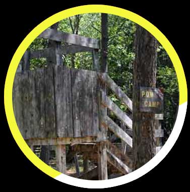 A wooden house with stairs and a sign that says paw camp