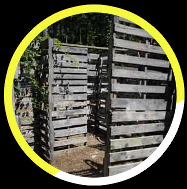 A fence made of wooden pallets is in a yellow circle.