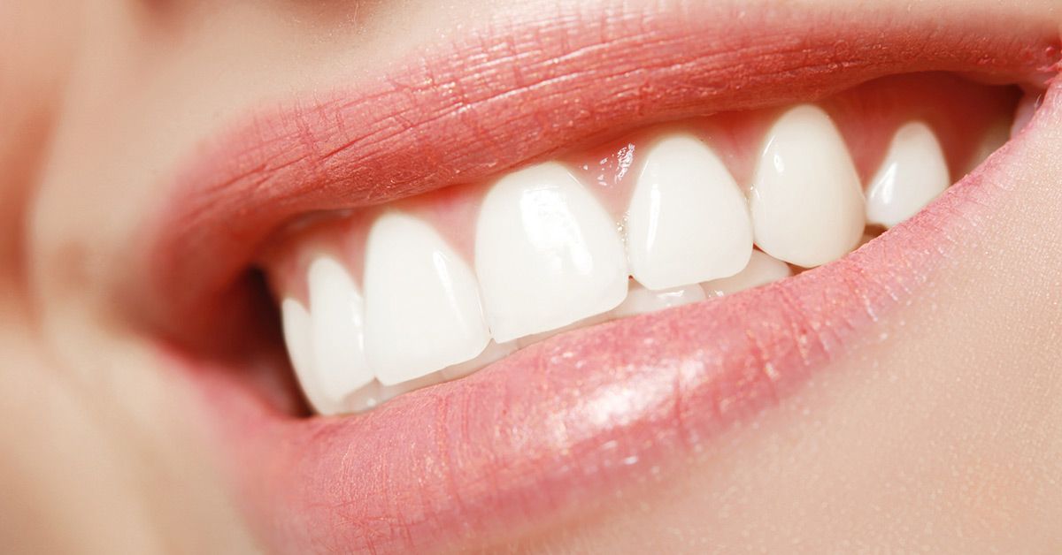 Close-up of smiling mouth with bright white teeth and pink lips.