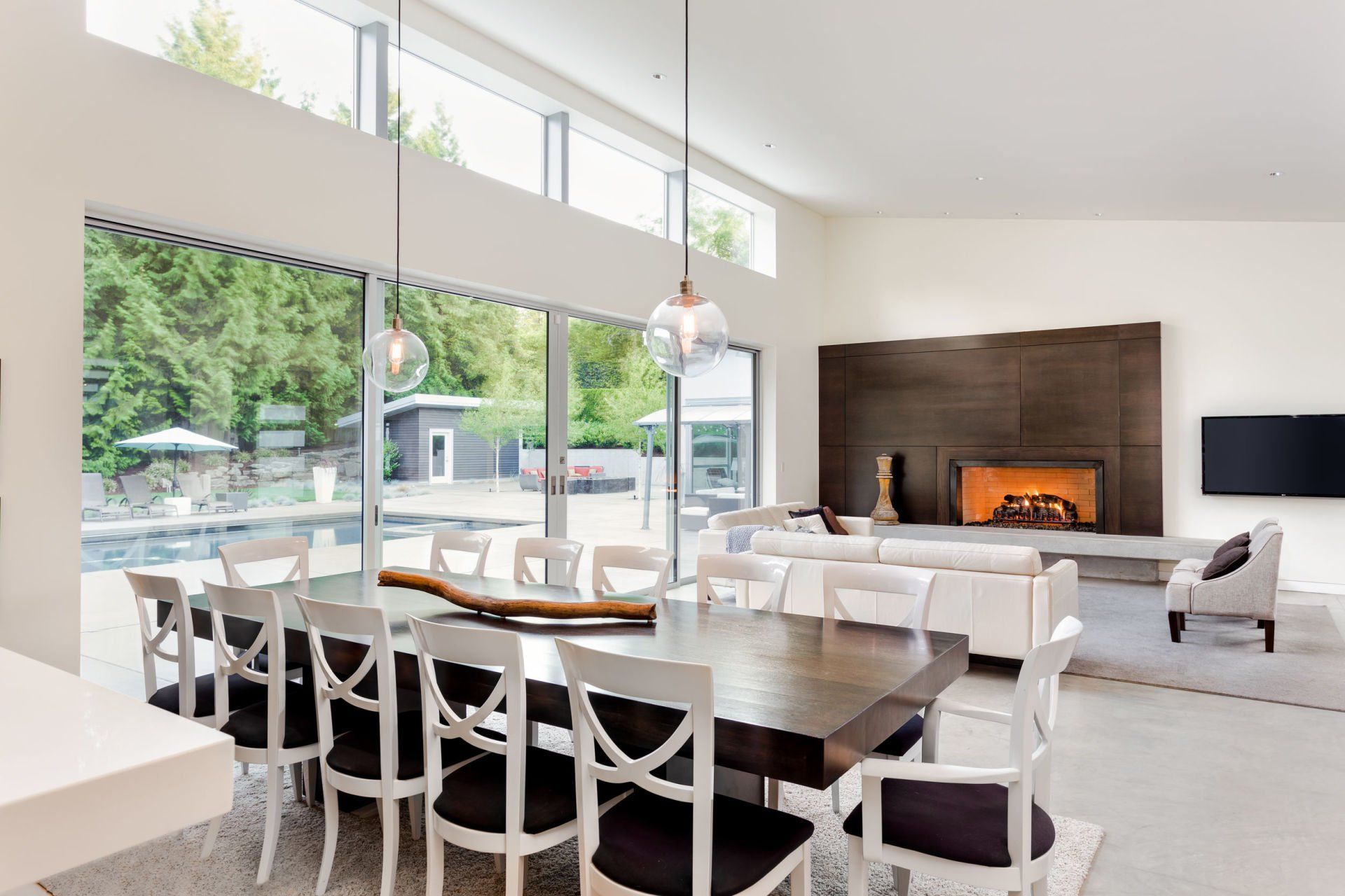 A living room with a dining table and chairs and a fireplace.