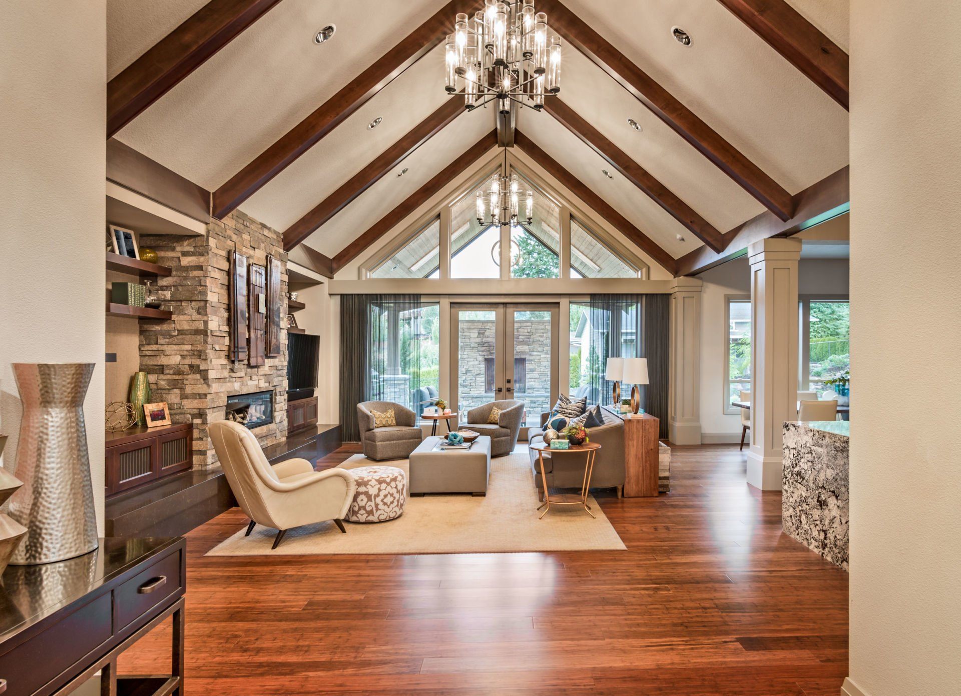 A large living room with a vaulted ceiling and wooden beams.