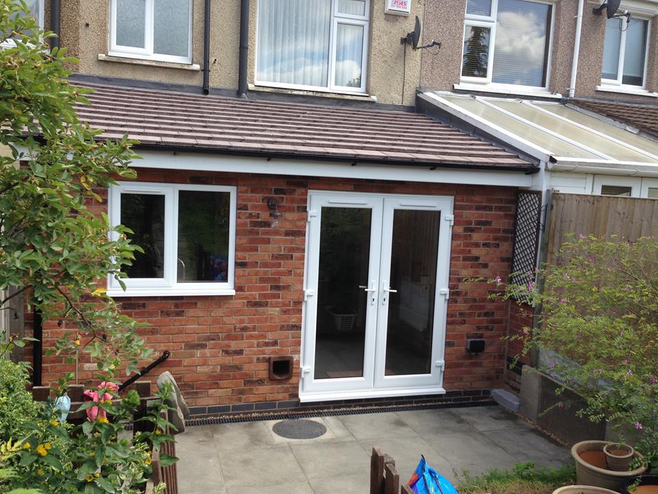 A lean-to extension with double uPVC doors leading out on to a patio area. This shows the rear of the property.