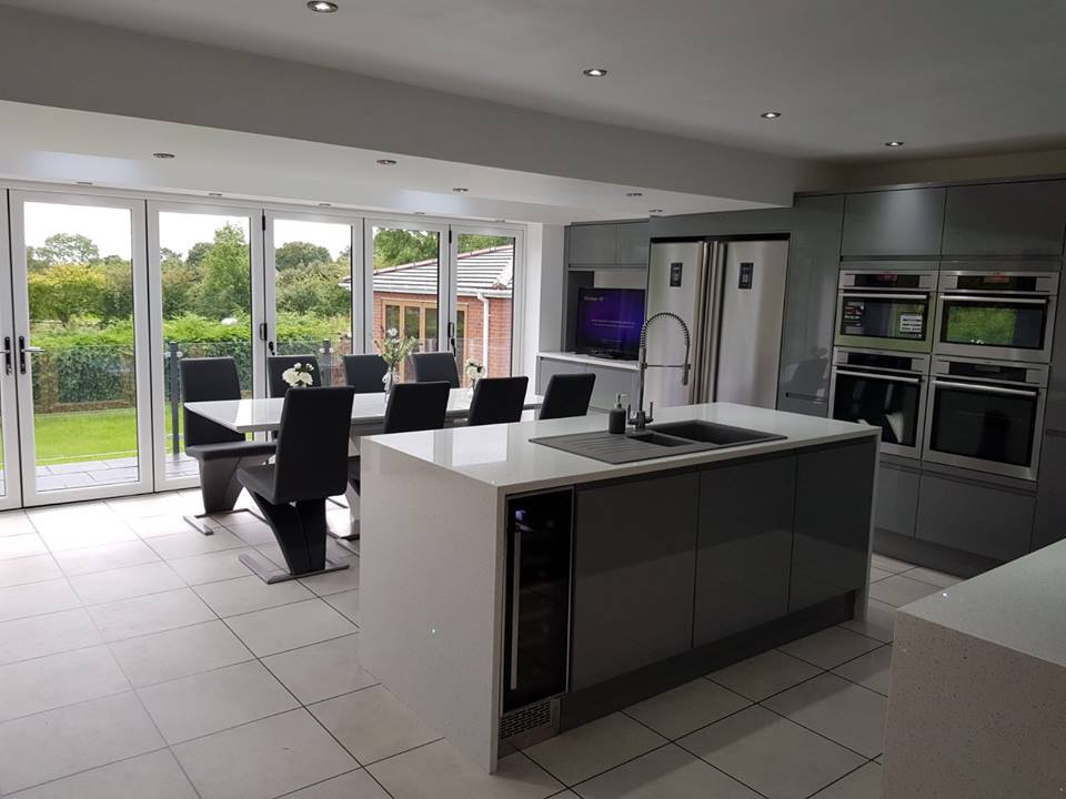 A large, modern, newly-fitted kitchen with a marble-topped island in the middle.