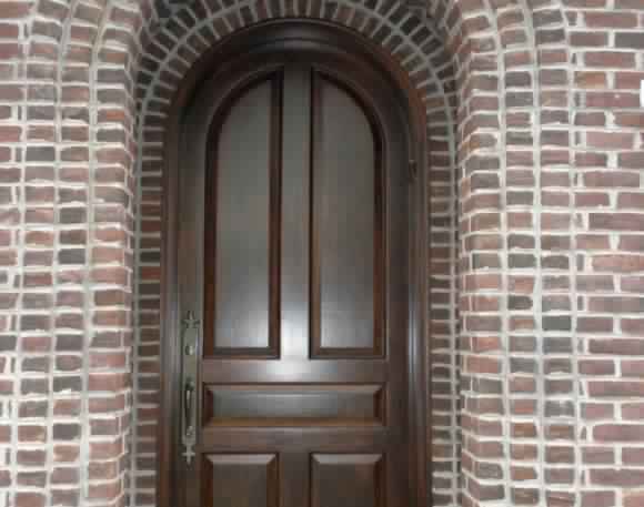dark brown wood door with curved top