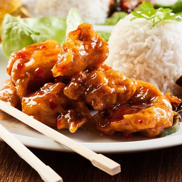 A plate of food with chopsticks and rice on a table