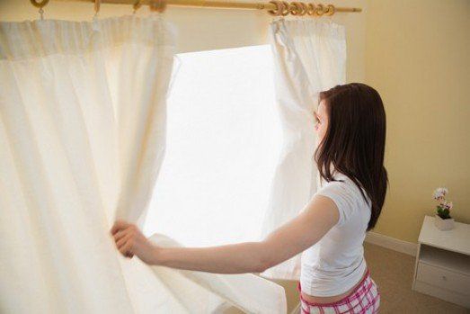 Woman Opening Curtains — Window Blinds in Red Bank, NJ Woman Opening Curtains — Window Blinds in Red Bank, NJ