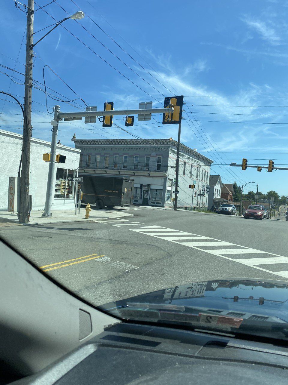 A car is driving down a street with a building in the background