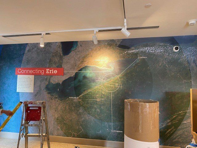 A wall with a map on it and a sign that says connecting erie