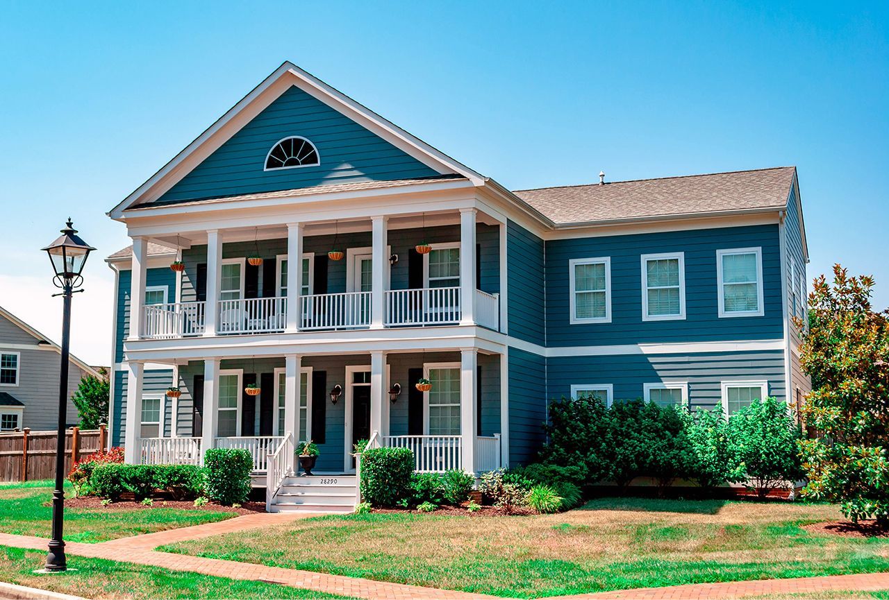 A large blue and white house with a large porch.