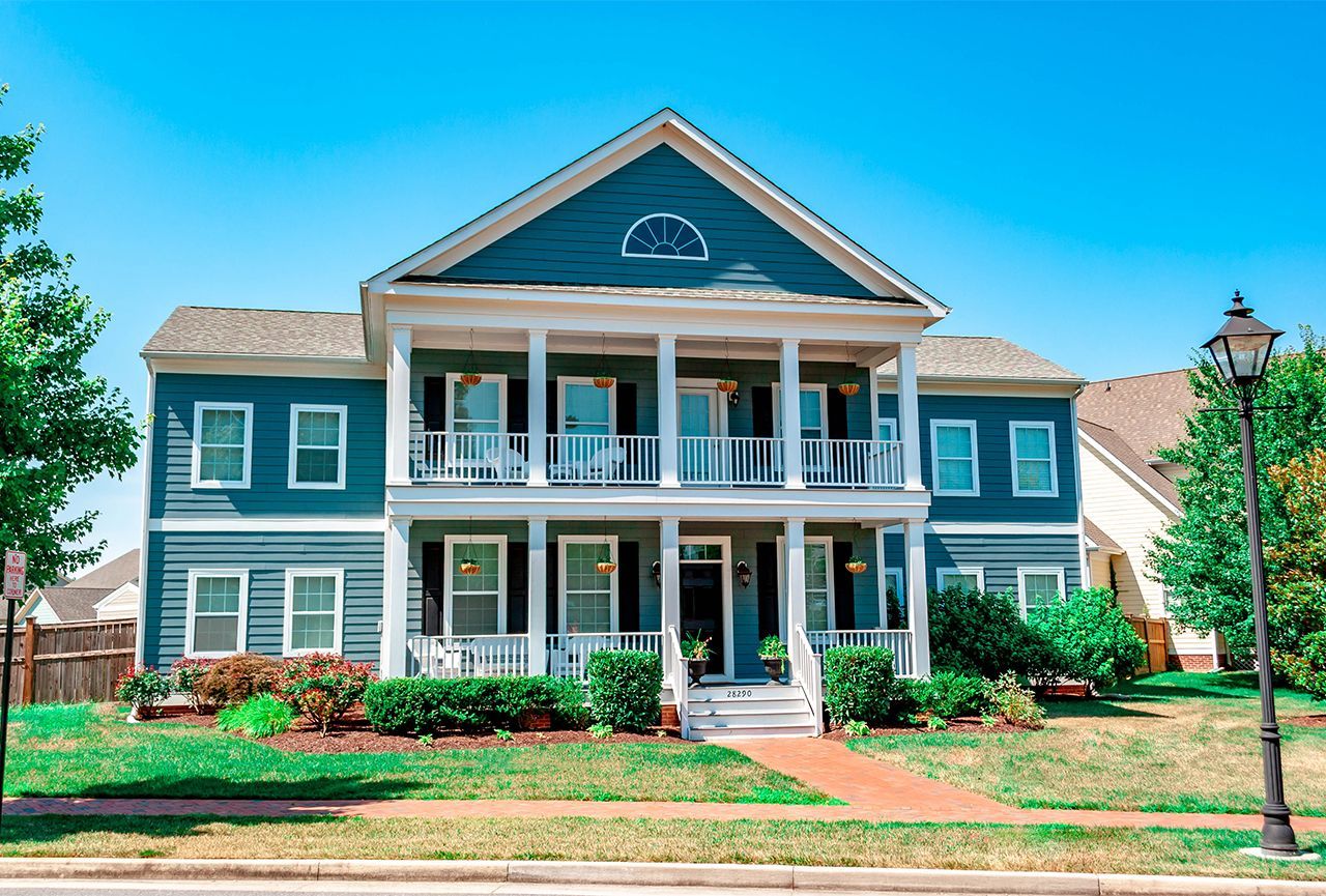 A large house with a lot of windows and a large porch.