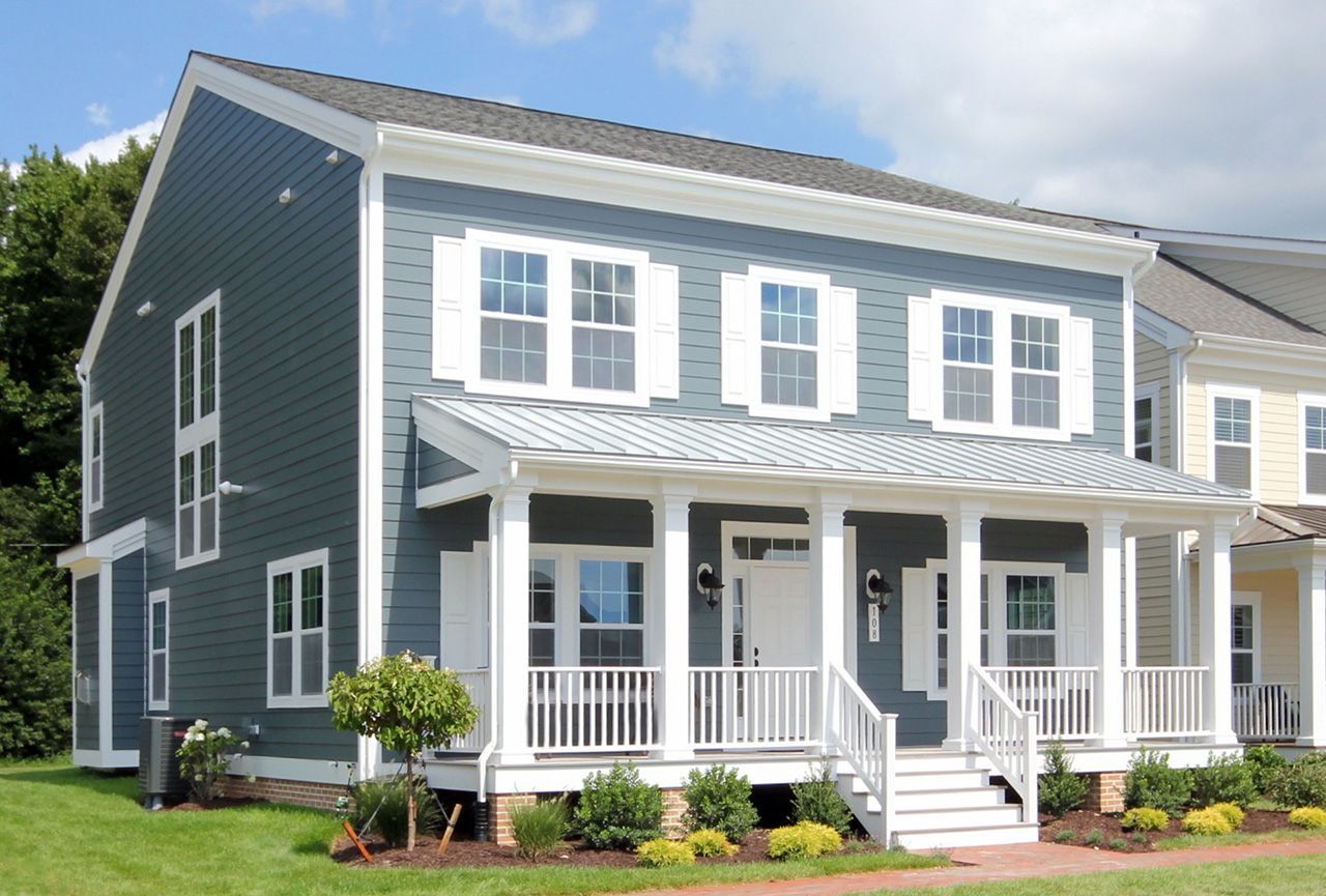 A blue house with white trim and a large porch