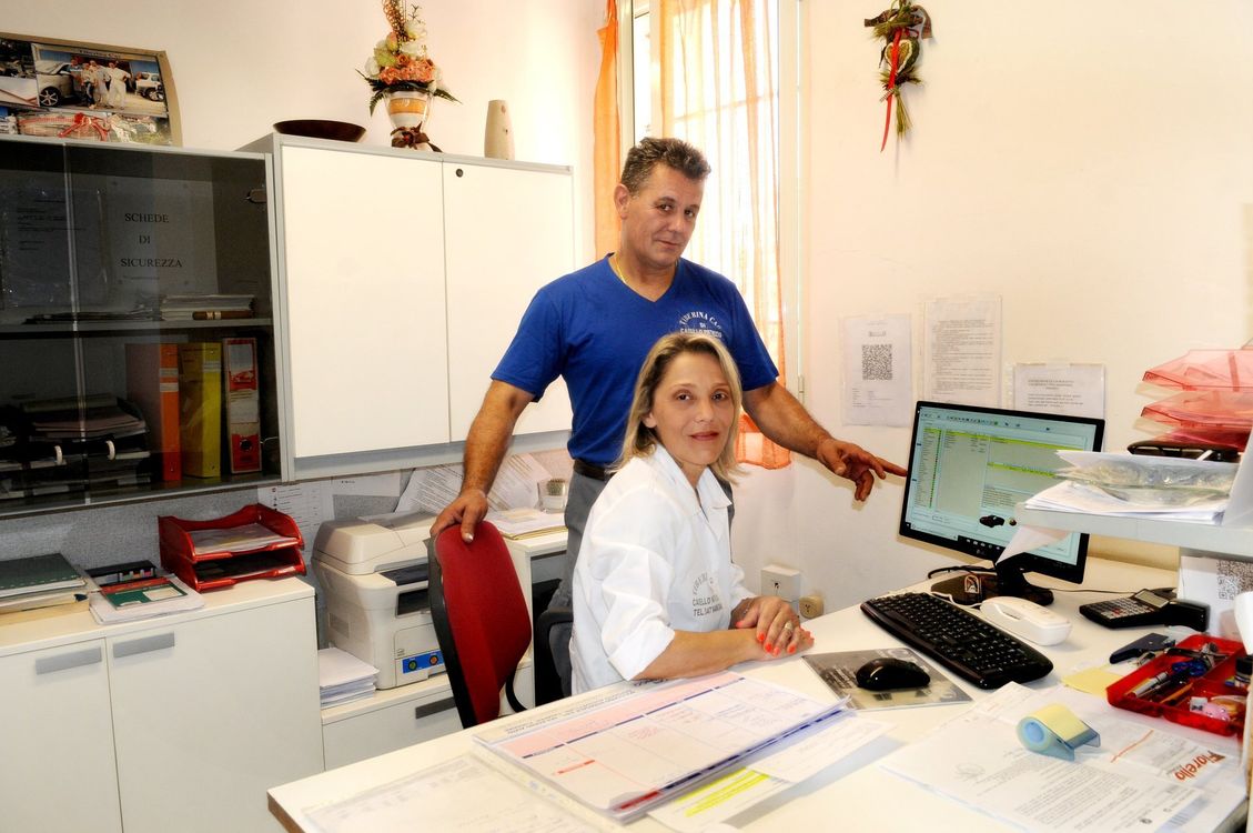 Due persone in un ufficio luminoso esaminano lo schermo di un computer e dei documenti a una scrivania.
