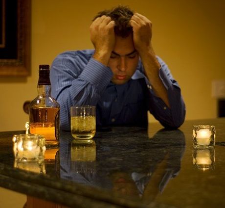 man holding head at counter