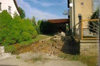 Ein Bild von einem Haus und einer unbefestigten Straße.