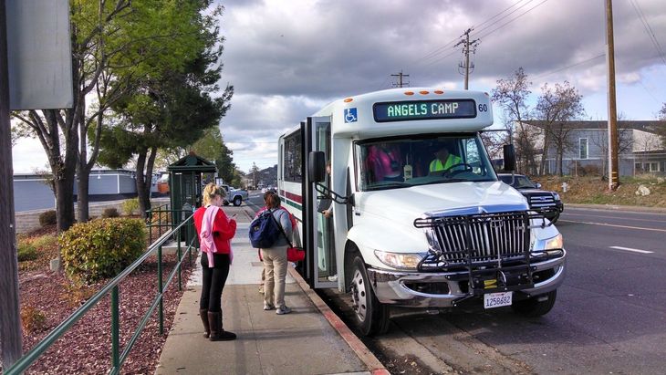Passenger loading his bicycle on the front of bus