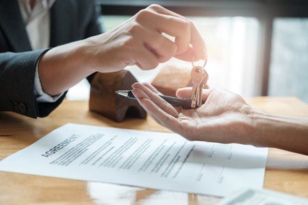 A property manager handing keys to renters