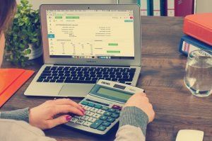 person with computer and calculator