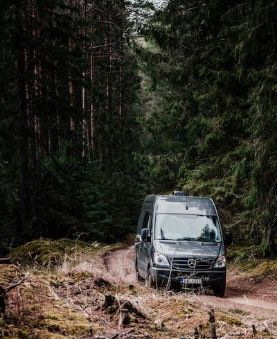 Van driving on a dirt road through the mountains