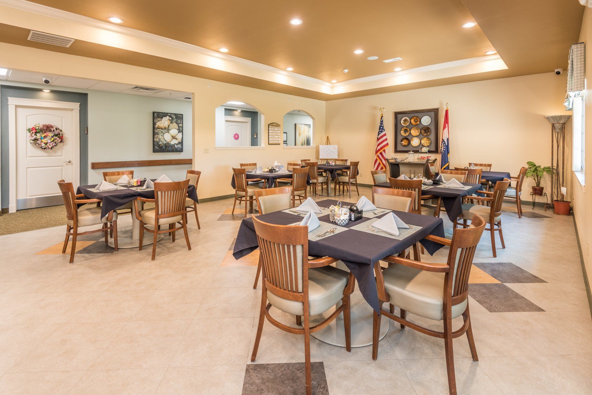 There are many tables and chairs in the room.