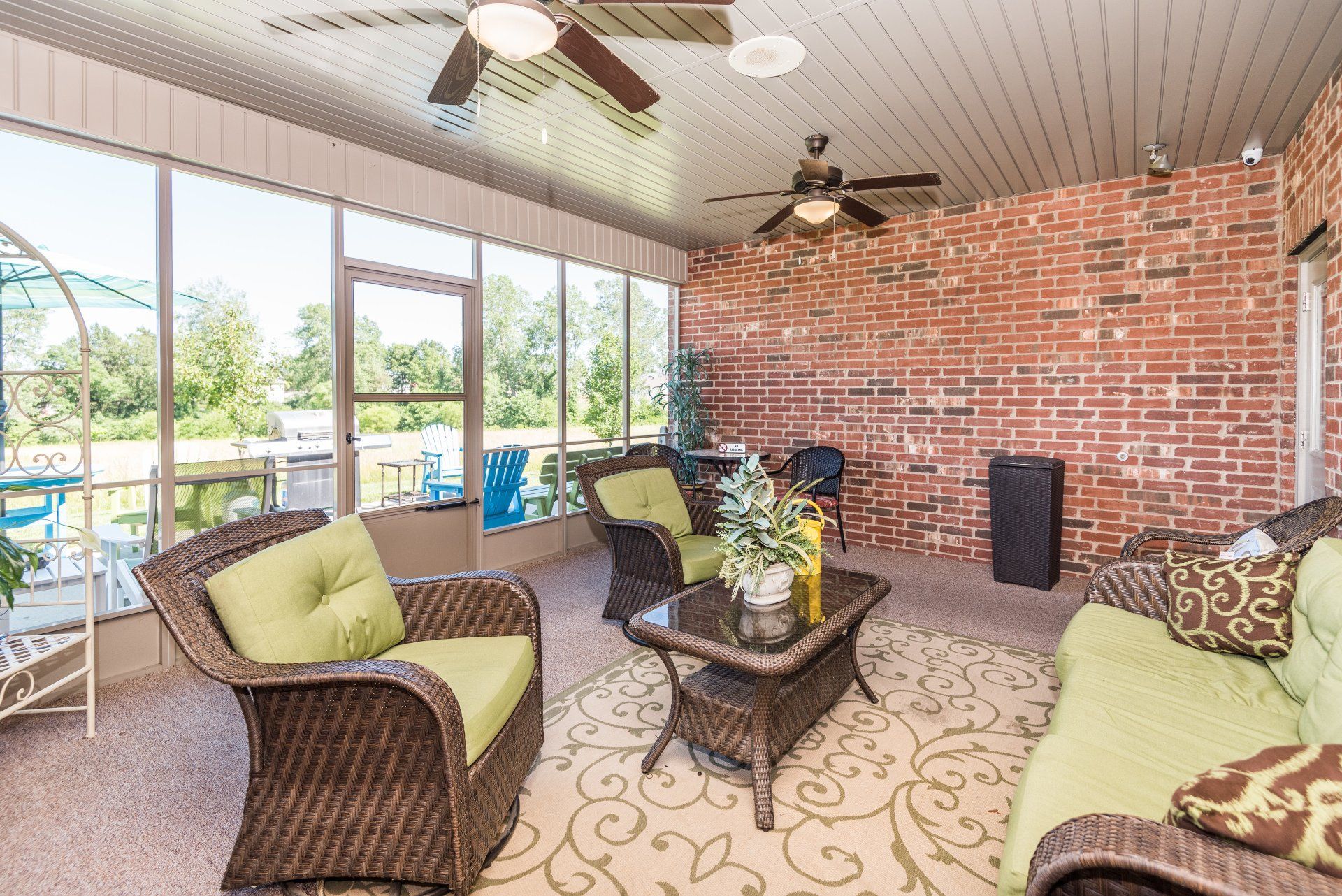 A living room with wicker furniture and a ceiling fan.