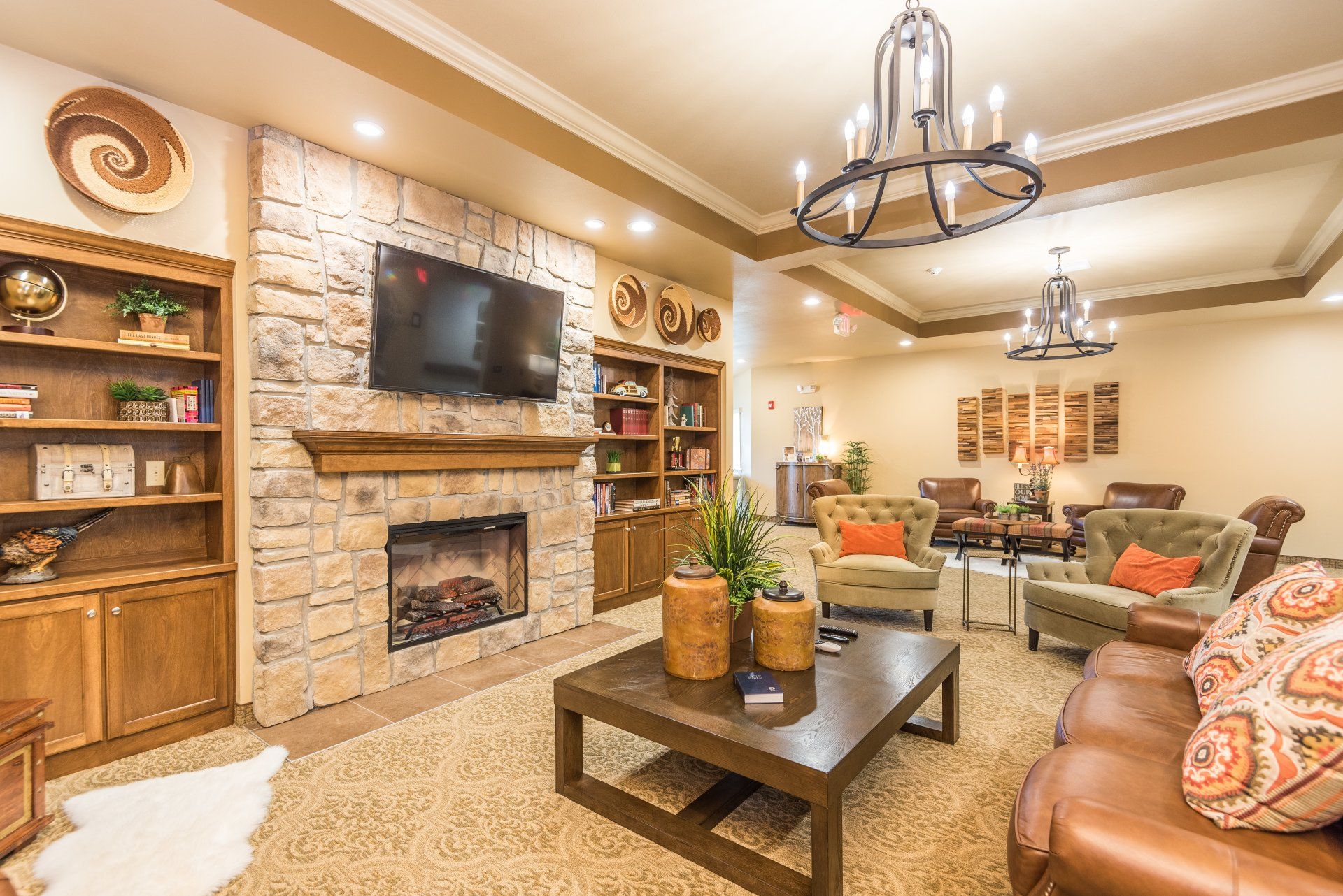 A living room with a fireplace, couch, chairs, coffee table and television.