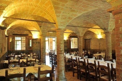 trattoria con soffitto in pietra e tavoli in legno