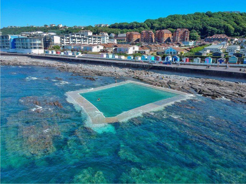 Sea pool shot from a drone showing the position of it in the rock pools and how it covers at high water. This sea water swimming pool is very popular now with many people using it for cold water dipping